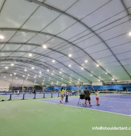 Curved roof aluminum alloy clear span tent sheltering indoor tennis courts.
